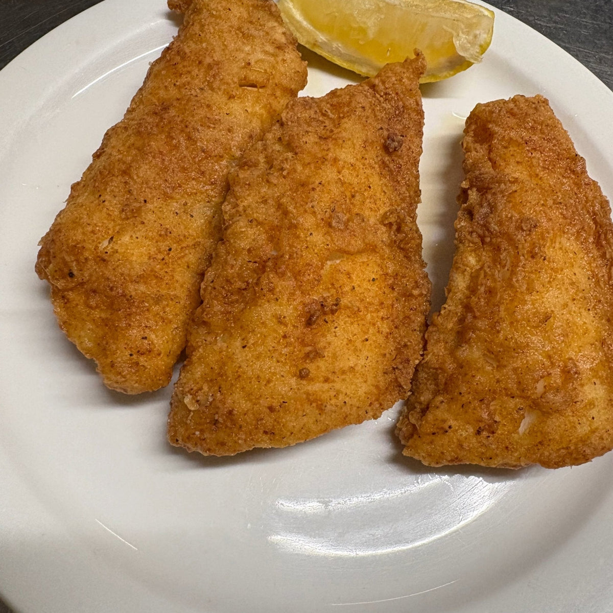 Crispy golden beer battered fish fillets made with Kalmes SUPERB BLEND Breading Mix, served with lemon wedges and tartar sauce