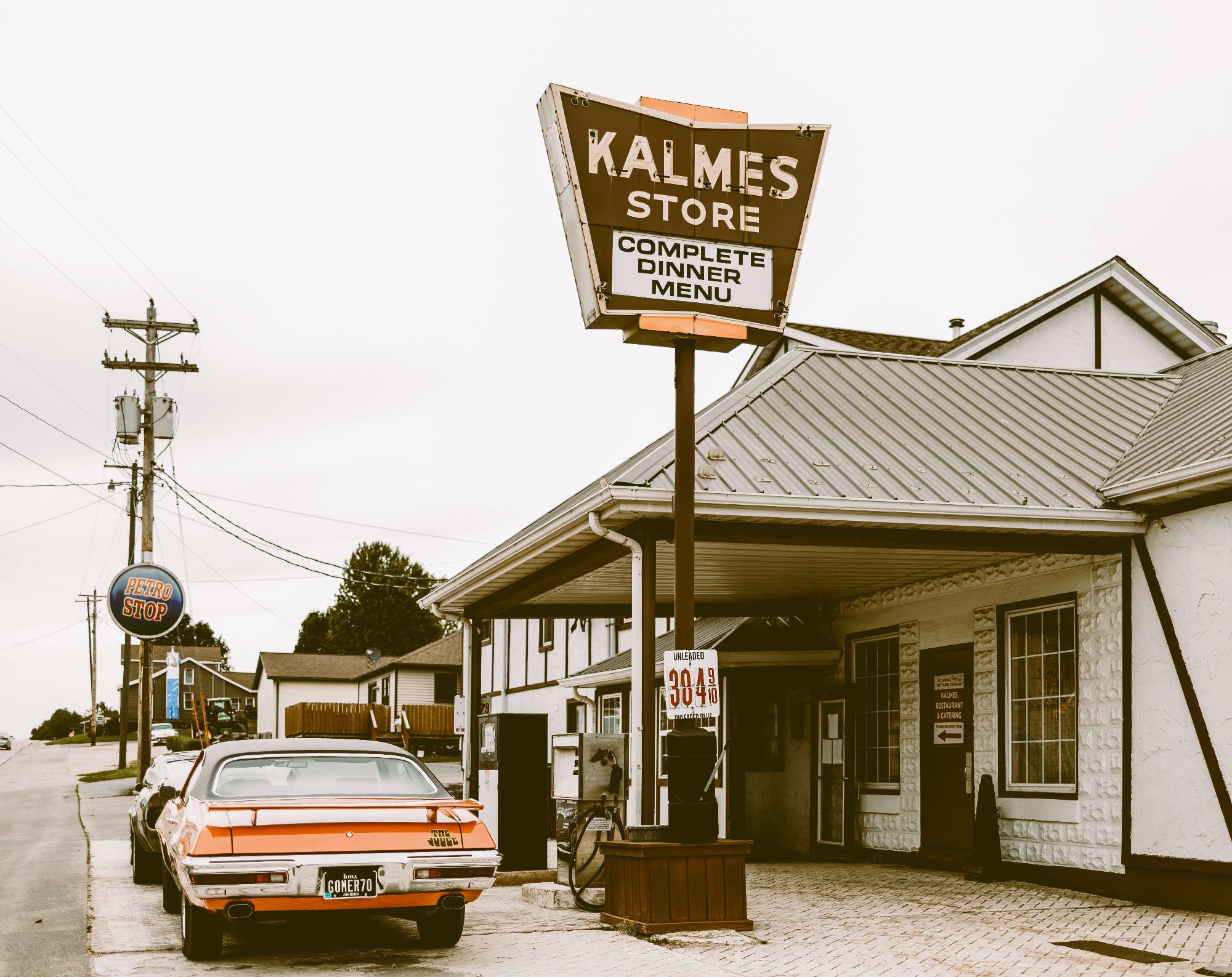 Vintage Kalmes Store with a sign and classic car in front, black and white photo.