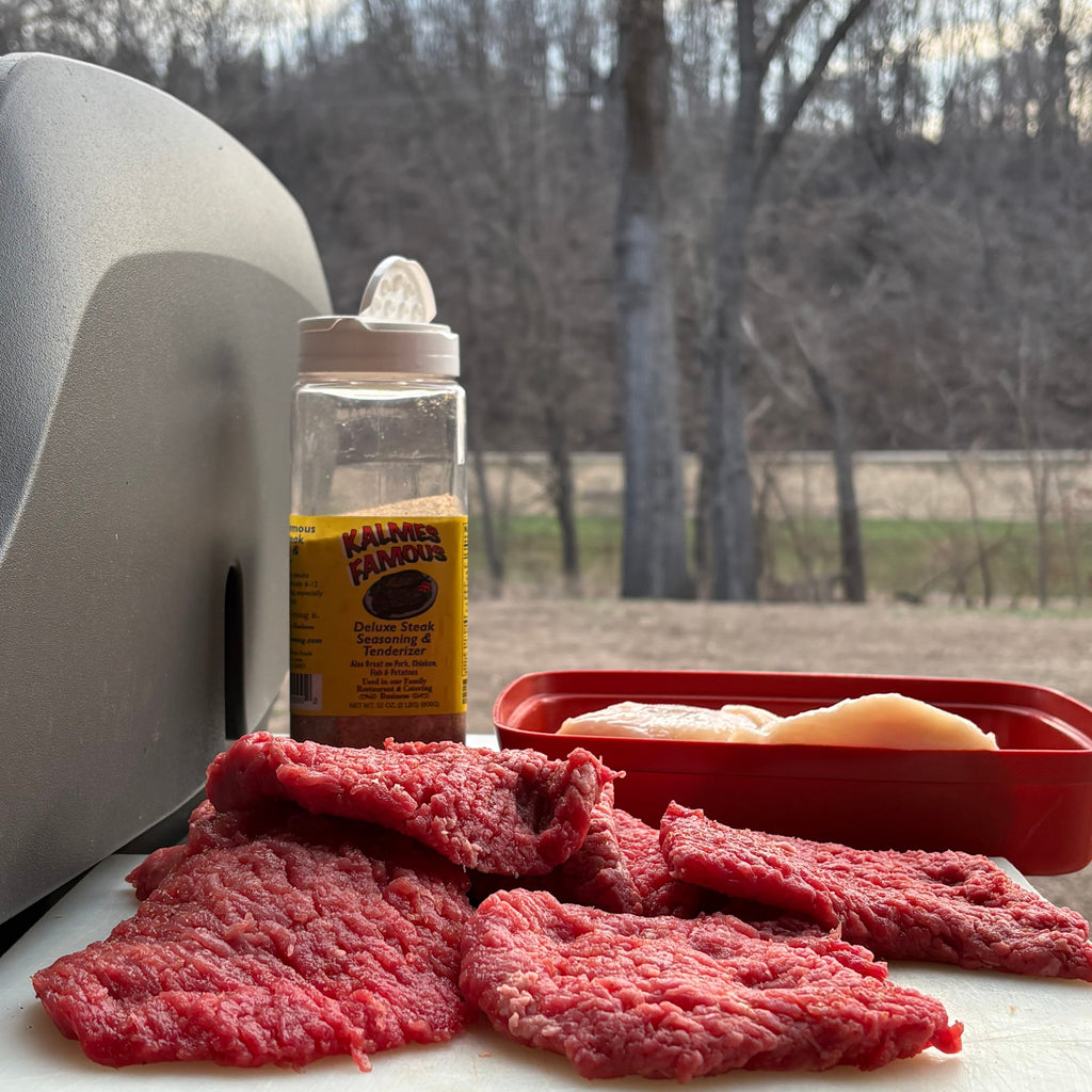 Minute Steak on a cutting board with a bottle of seasoning outdoors. 2-in-1 Steak Seasoning & Meat Tenderizer