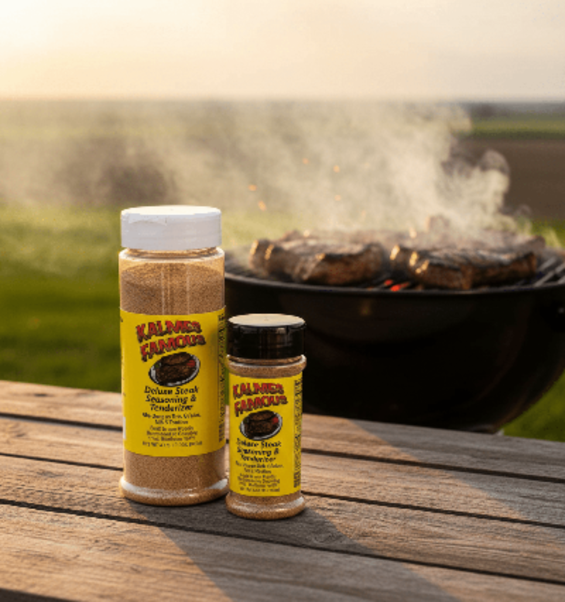 Two bottles of Kalme's Famous steak and chicken tenderizer on a wooden table with a grill in the background.